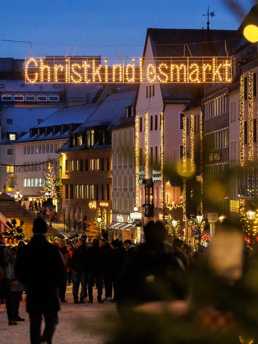 Der Leuchtschriftzug "Christkindlesmarkt" hängt über dem Gehweg zum Nürnberger Weihnachtsmarkt.