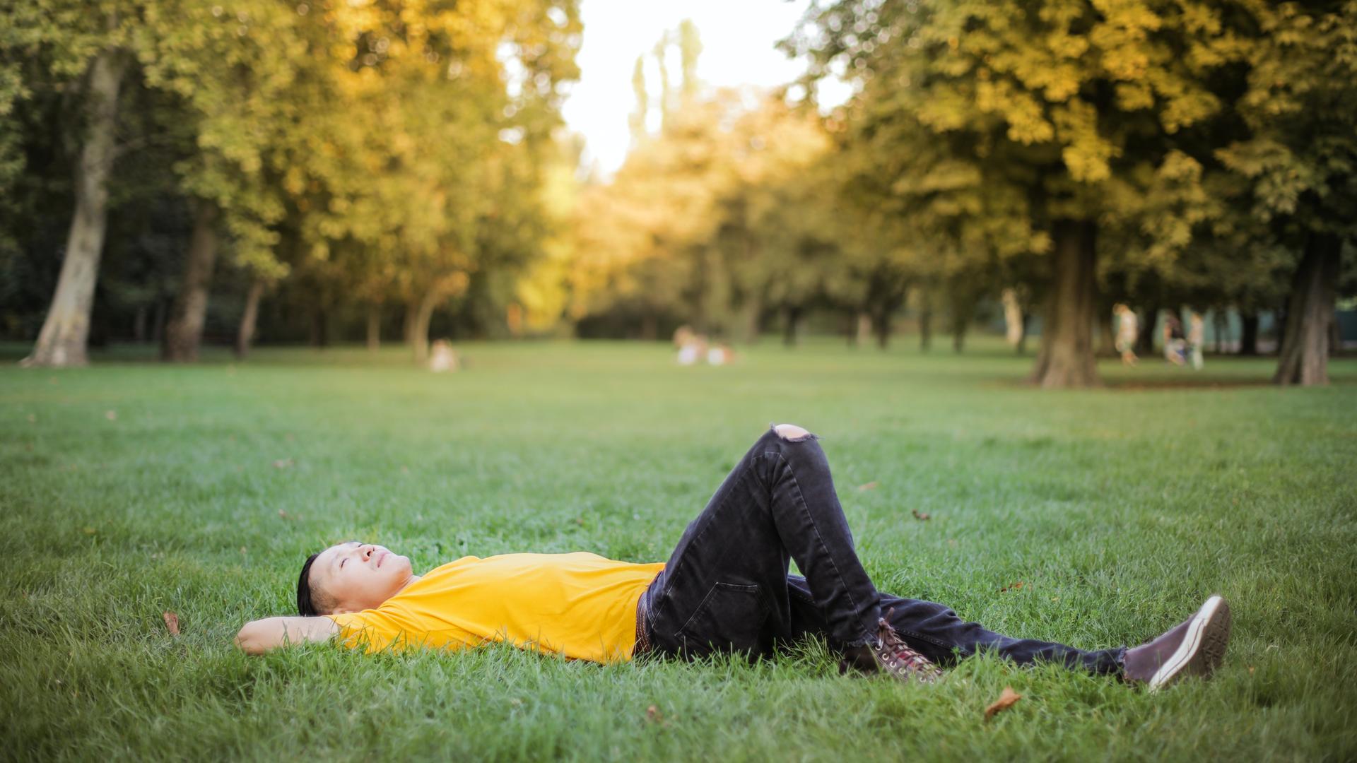 Mensch liegt auf Wiese. 