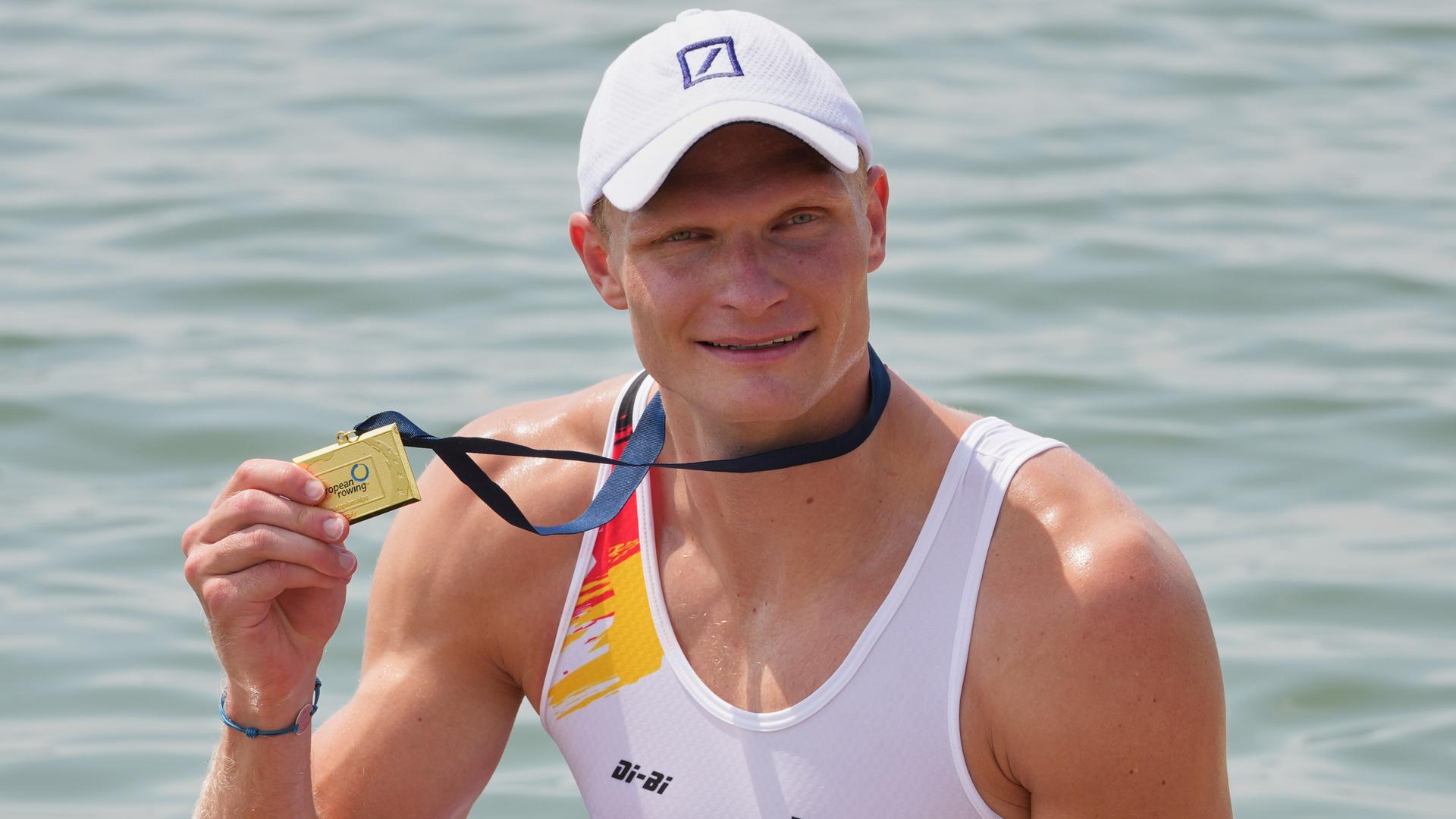 Oliver Zeidler nach seinem Sieg im Einer: Er hält mit der rechten Hand die Goldmedaille hoch. Oliver Zeidler nach seinem Sieg im Einer: Er hält mit der rechten Hand die Goldmedaille hoch.