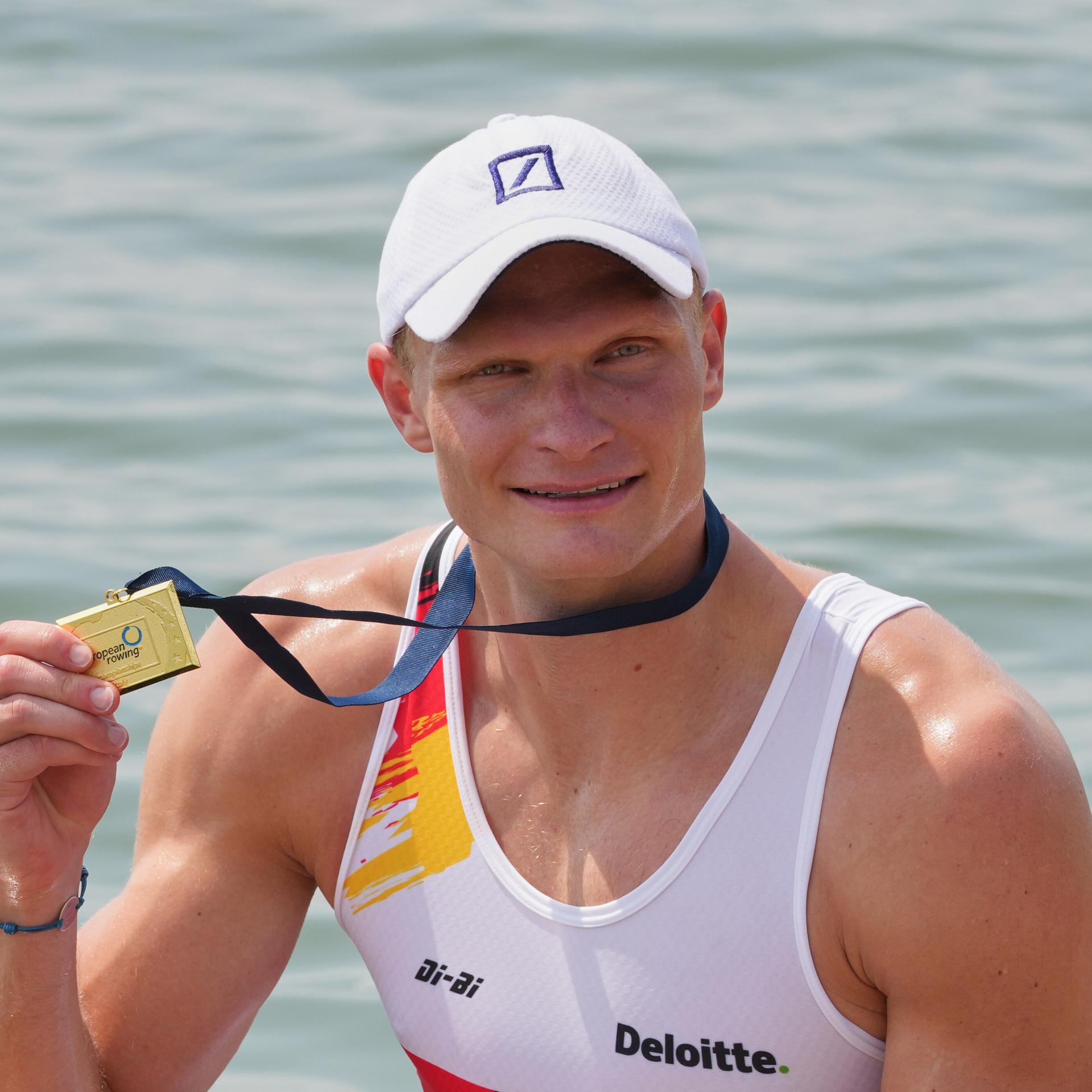 Oliver Zeidler nach seinem Sieg im Einer: Er hält mit der rechten Hand die Goldmedaille hoch. 