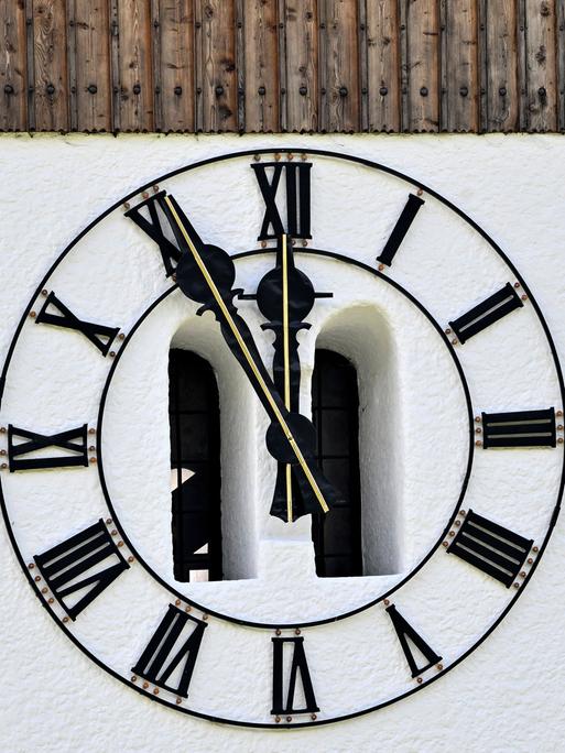 An einer historischen Kirchenuhr steht es fünf vor zwölf.