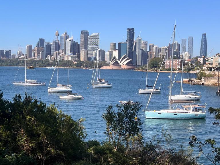 Panoramaansicht von Segelbooten und Yachten, die vor der Skyline der Innenstadt von Sydney vor Anker liegen