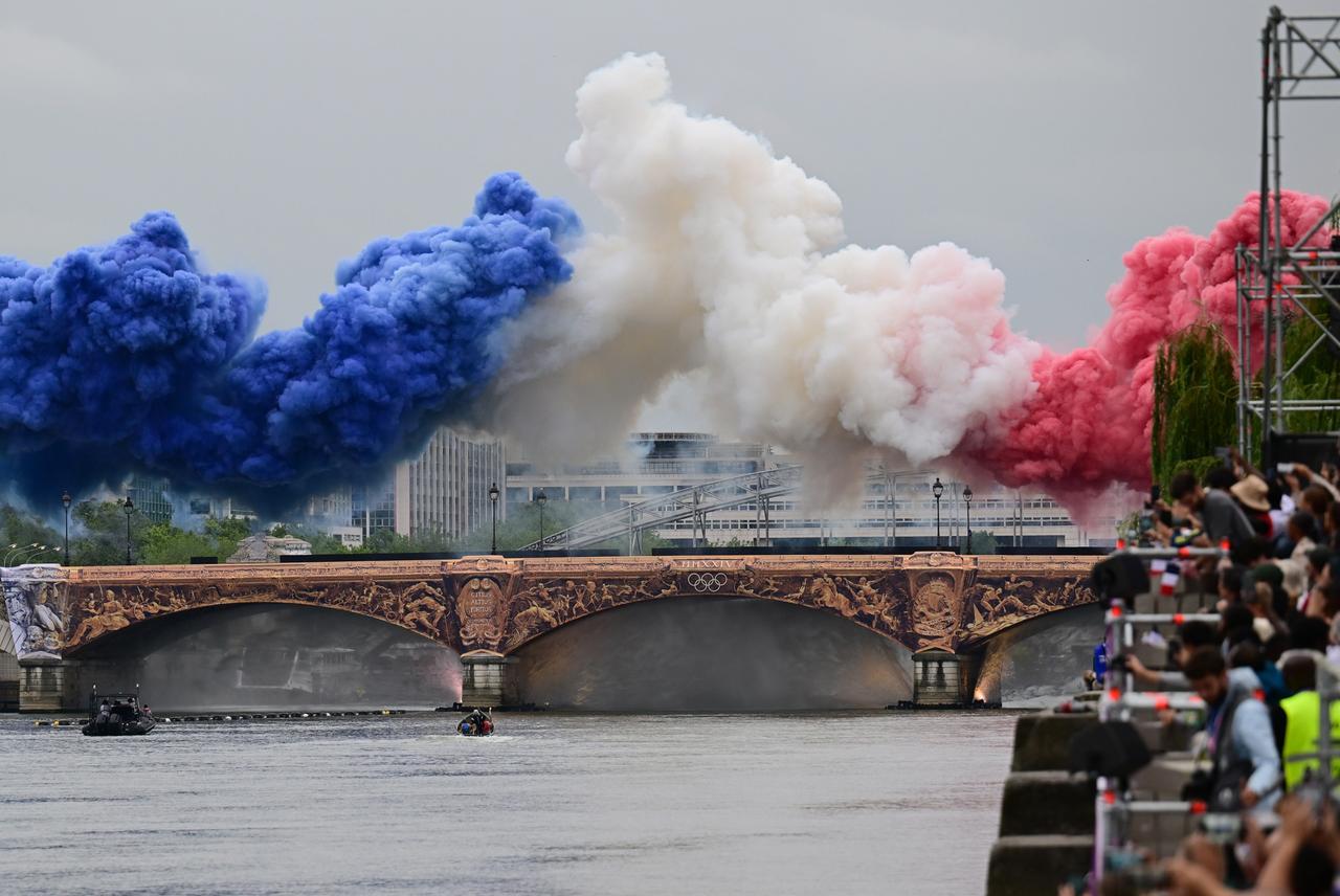 Pyrotechnik in den Farben der französischen Nationalflagge - blau, weiß, rot - wird über einer Brücke auf der Seine gezündet.