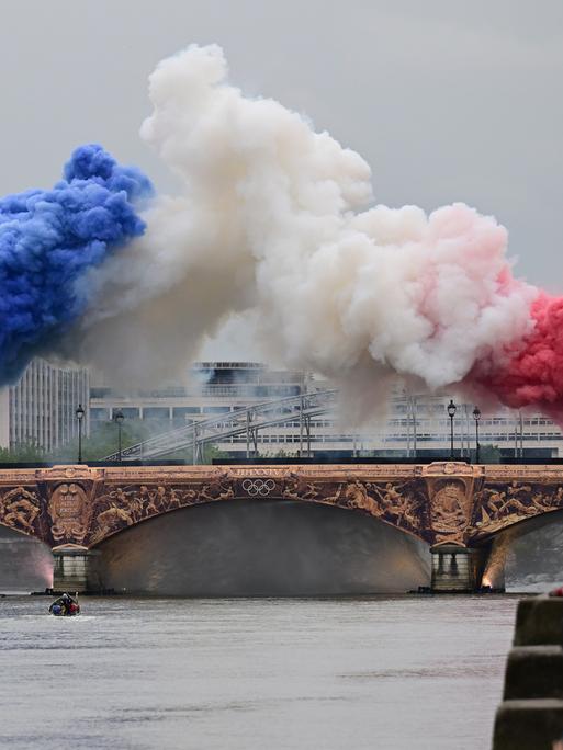 Pyrotechnik in den Farben der französischen Nationalflagge - blau, weiß, rot - wird über einer Brücke auf der Seine gezündet.