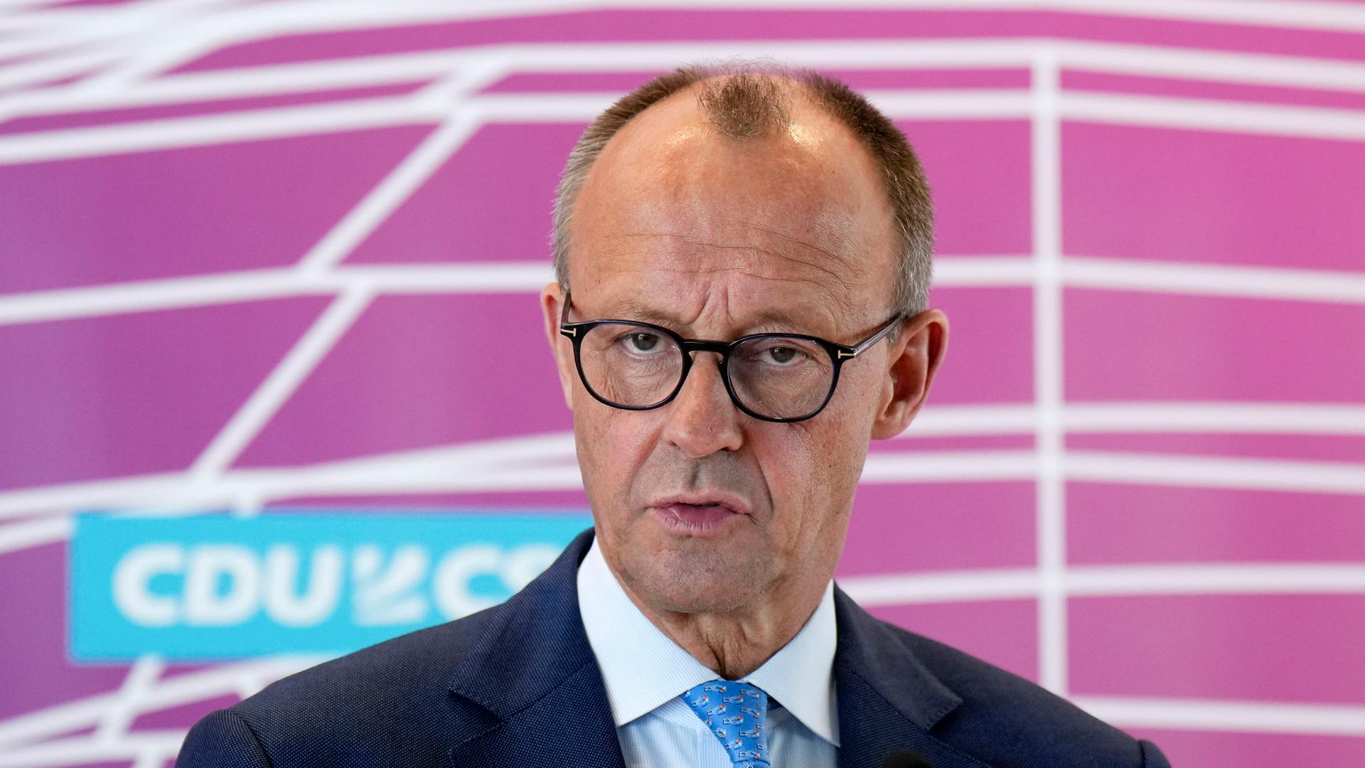 Friedrich Merz bei einem Pressetermin im Reichstagsgebäude am 5. Juli. Der 68-Jährige mit Brille, kurzem Haar und Halbglatze schaut in die Kamera. Im Hintergrund ist ein Logo von CDU und CSU zu sehen.