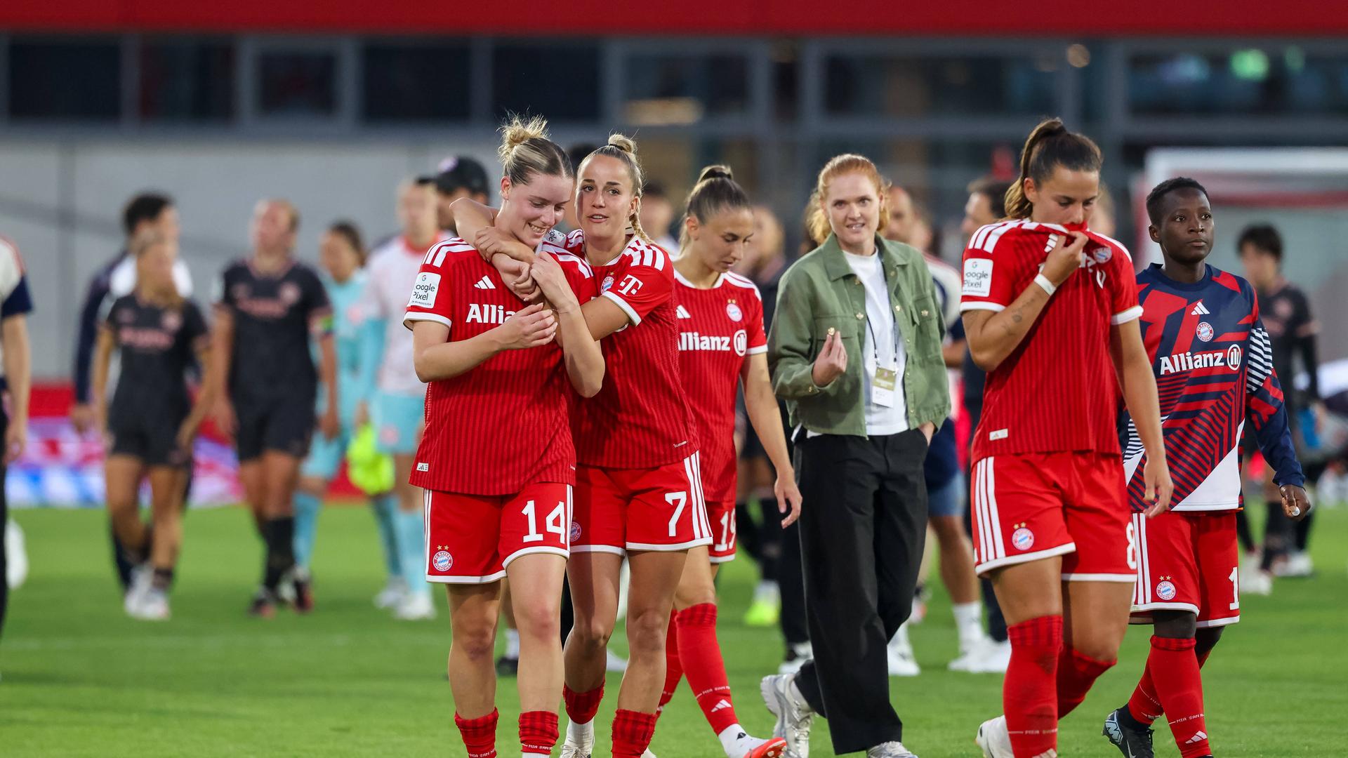 Giulia Gwinn mit Alara Sehitler und weiteren Spielerinnen auf dem Spielfeld. Sie freuen sich.