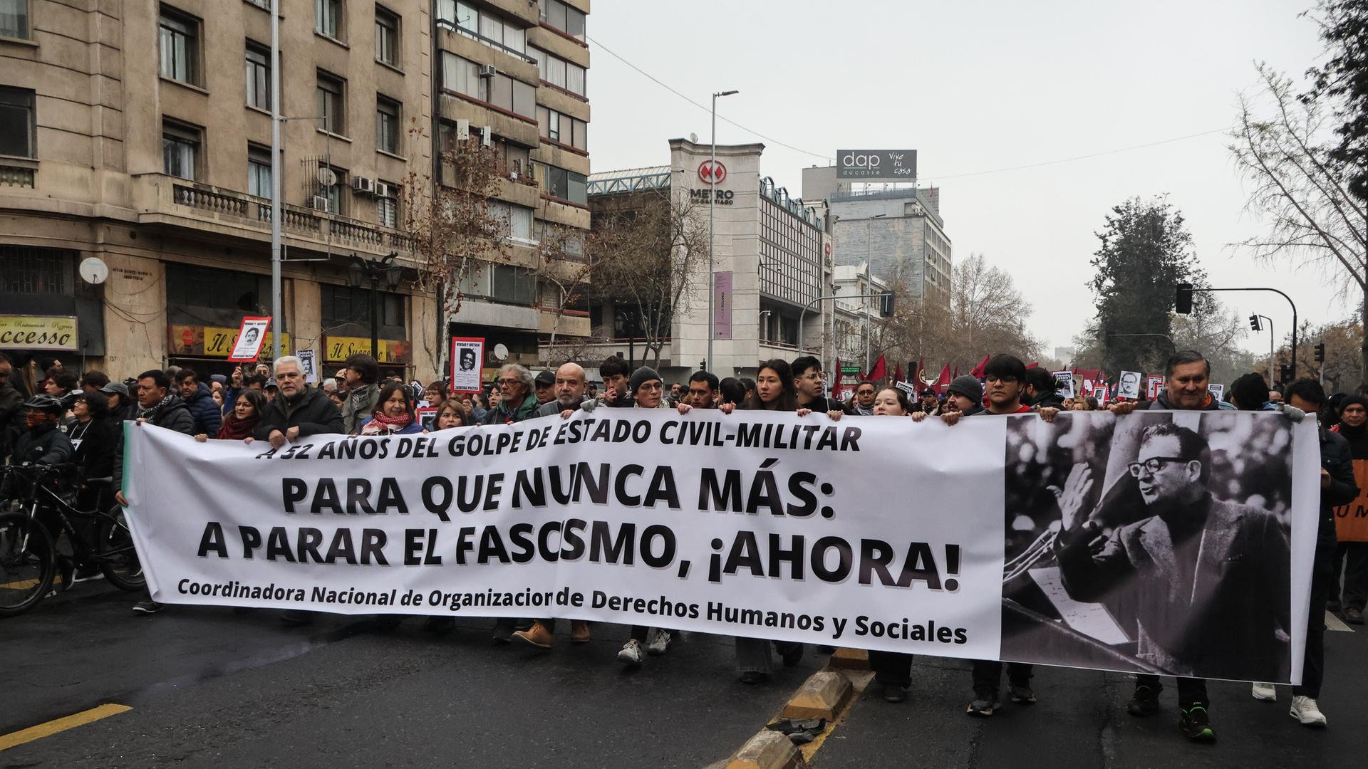 Menschen halten ein Transparent während des Marsches zum 52. Jahrestag des Militärputsches von 1973, einer jährlichen Veranstaltung zum Gedenken an die Tausenden Opfer der Diktatur von Augusto Pinochet Ugarte. Menschen halten ein Transparent während des Marsches zum 52. Jahrestag des Militärputsches von 1973, einer jährlichen Veranstaltung zum Gedenken an die Tausenden Opfer der Diktatur von Augusto Pinochet Ugarte.