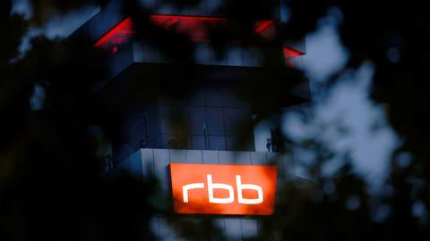 Das beleuchtete Logo des Senders Rundfunk Berlin-Brandenburg (RBB) ist an der Fassade am Sitz des Senders an der Masurenallee in Berlin angebracht.