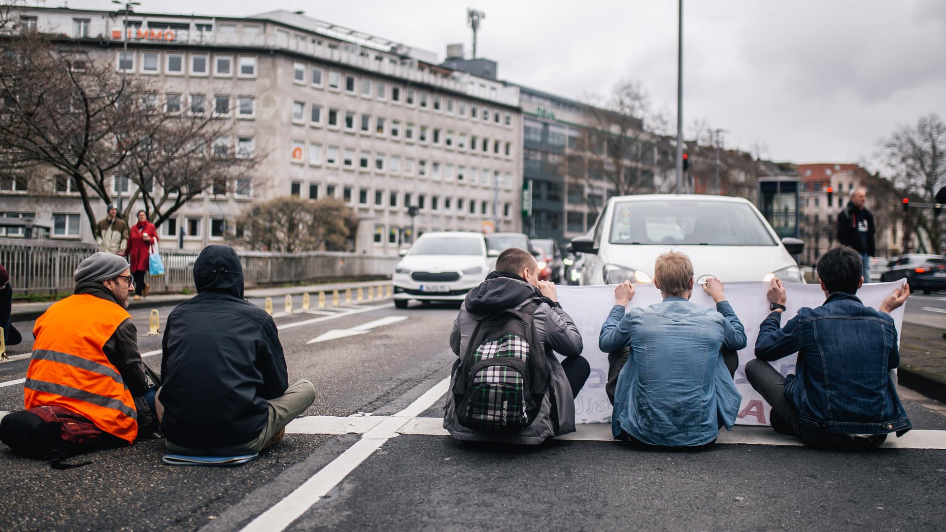 Klimaaktivisten sitzen auf einer Hauptverkehrsstraße in Köln.