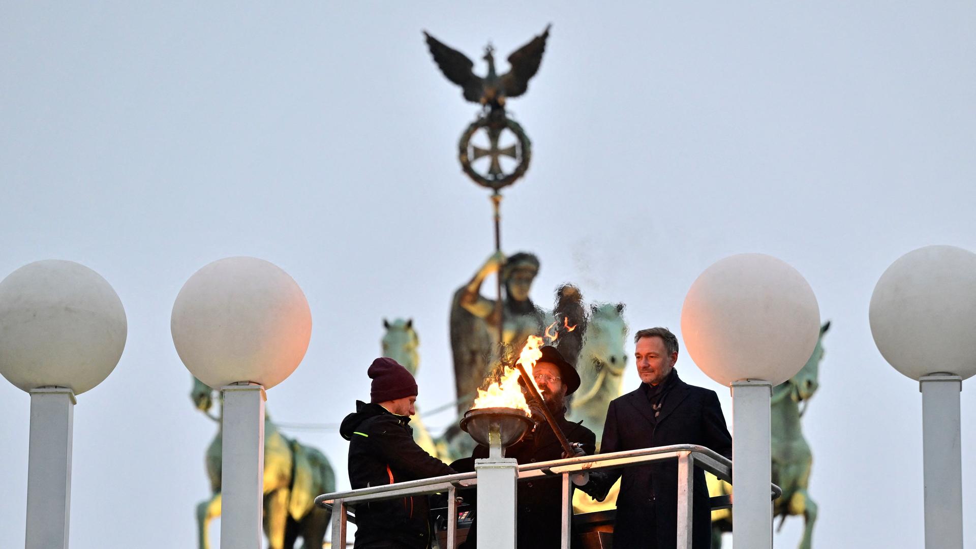 Am Brandenburger Tor in Berlin entzünden Bundesfinanzminister Lindner und Rabbiner Teichtal den Chanukka-Leuchter.