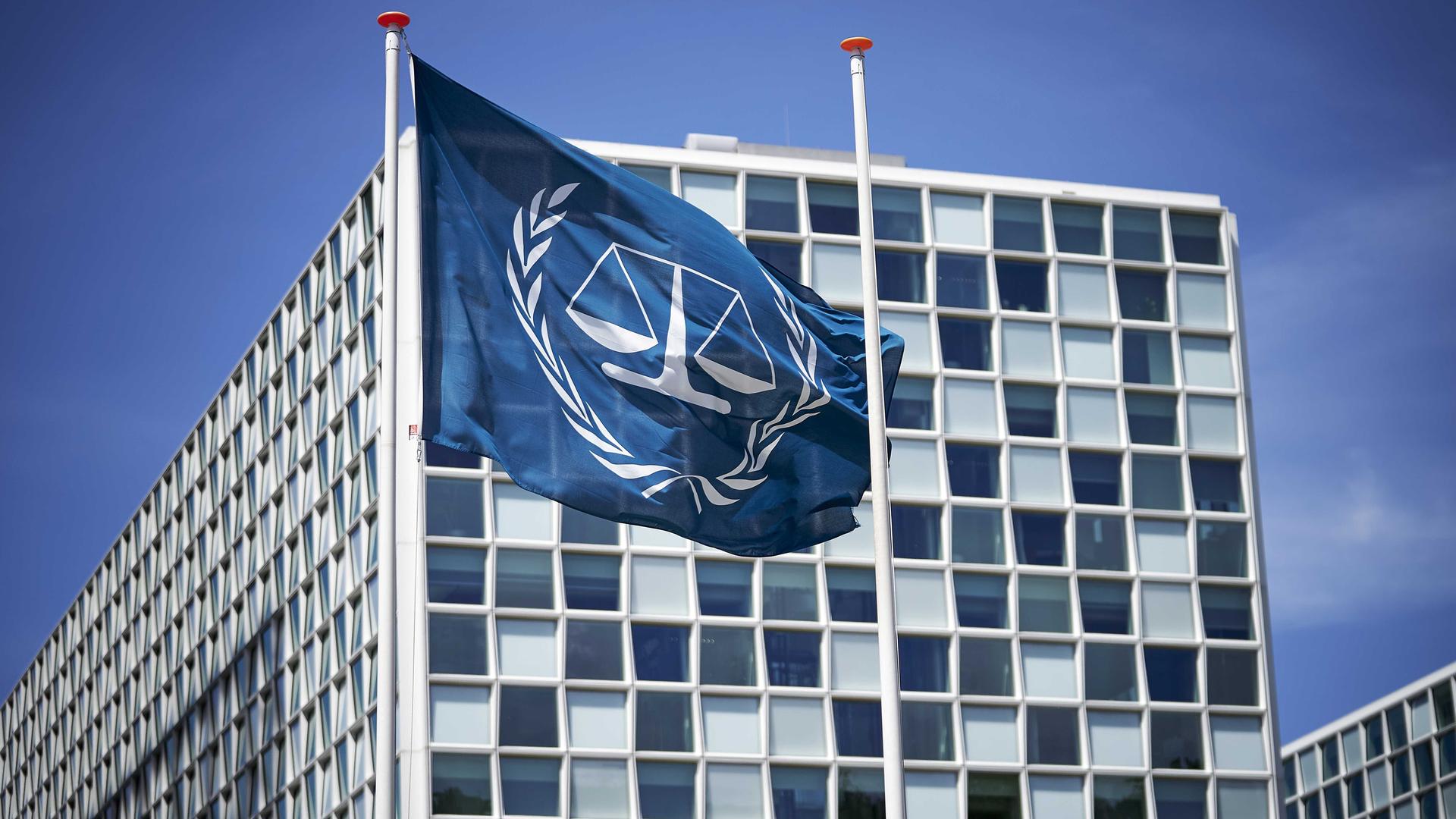Außenansicht des Internationalen Strafgerichtshofs (IStGH): Vor dem Gebäude weht an einem Mast eine Fahne mit dem Logo des IStGH. Außenansicht des Internationalen Strafgerichtshofs (IStGH): Vor dem Gebäude weht an einem Mast eine Fahne mit dem Logo des IStGH.