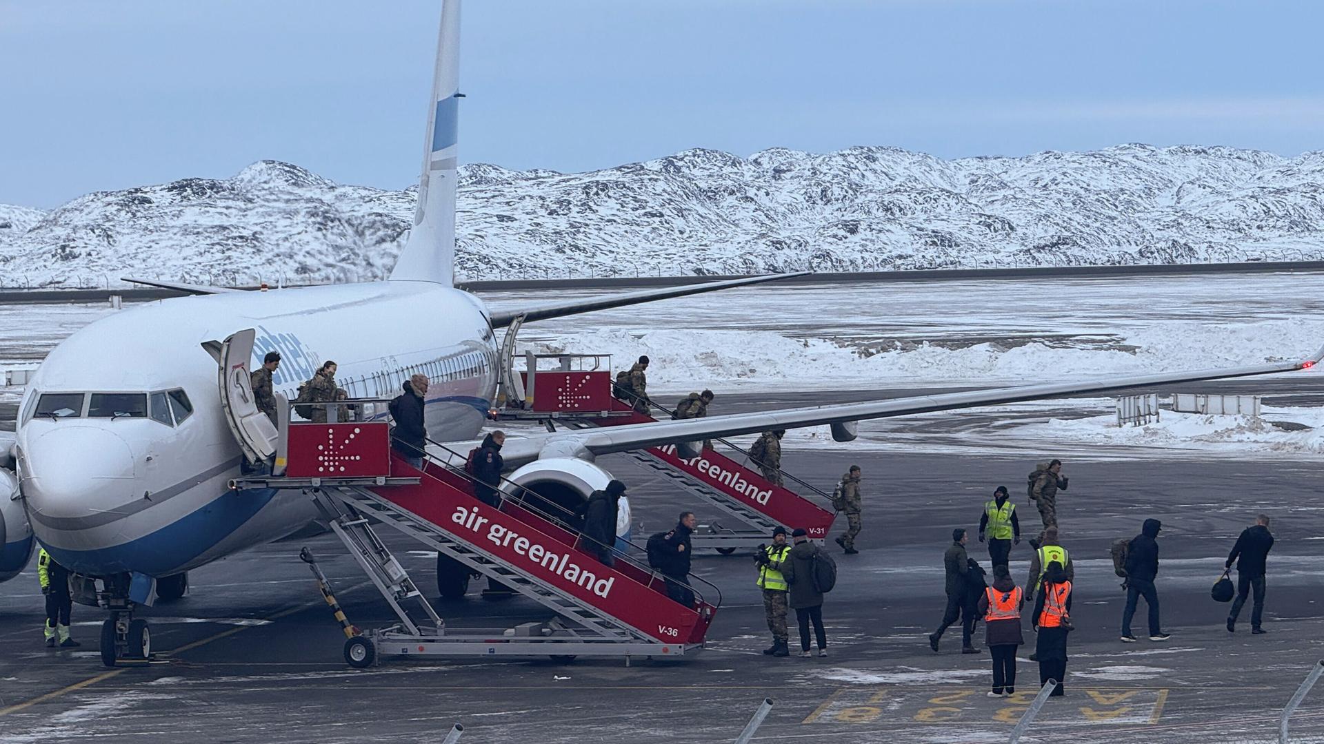Soldaten der Bundeswehr (hinten) verlassen das Flugzeug nach der Landung in Nuuk.