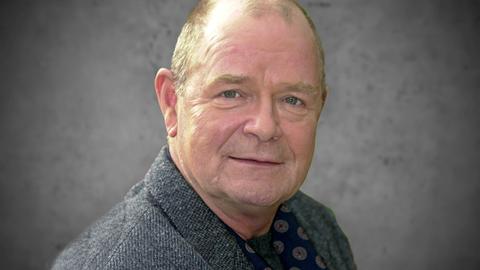 Porträt von Dieter Mann, ein älterer Mann mit Halbglatze und grauem Pullover