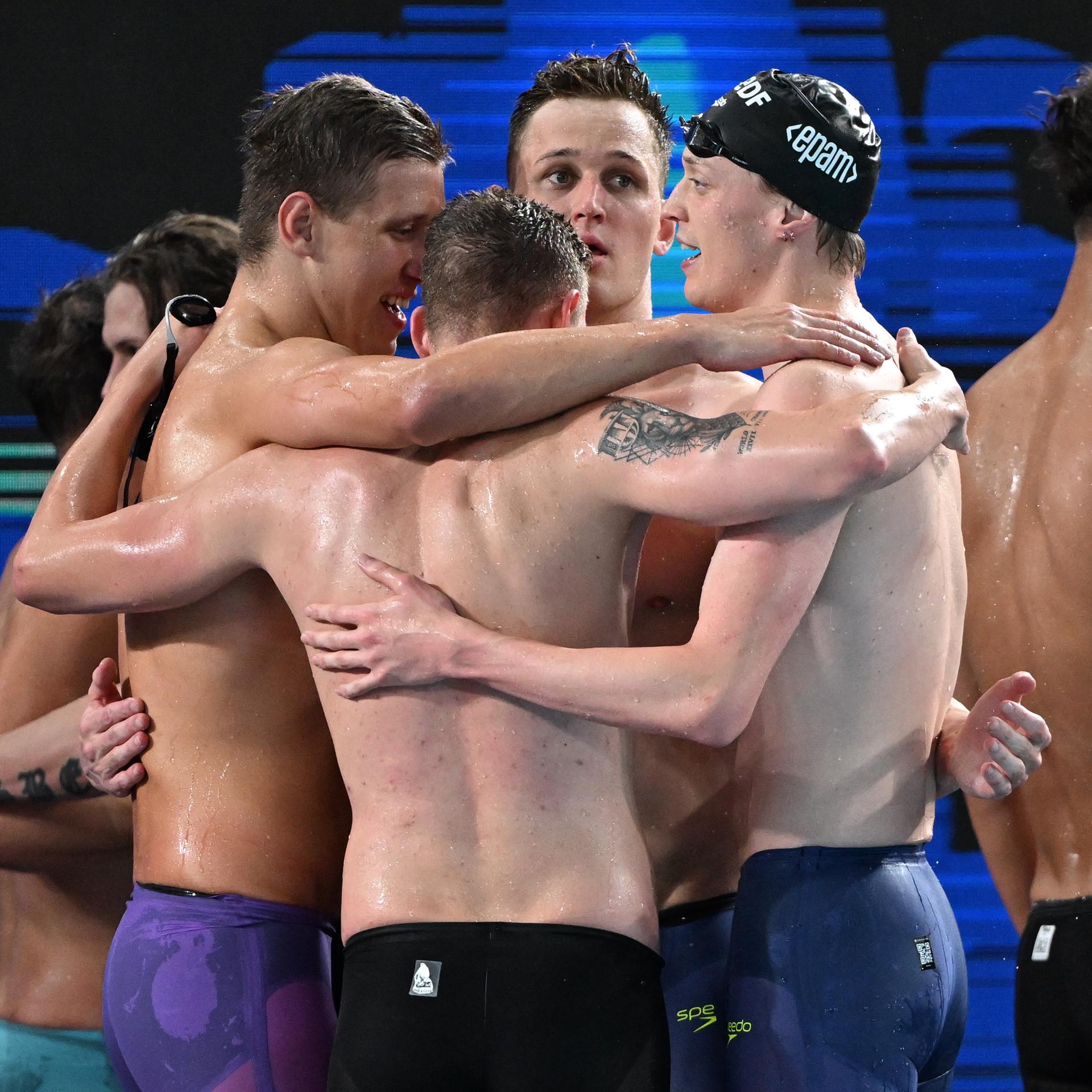 Vier deutsche Schwimmer bilden nach dem Rennen einen Kreis und umarmen sich zum Jubel