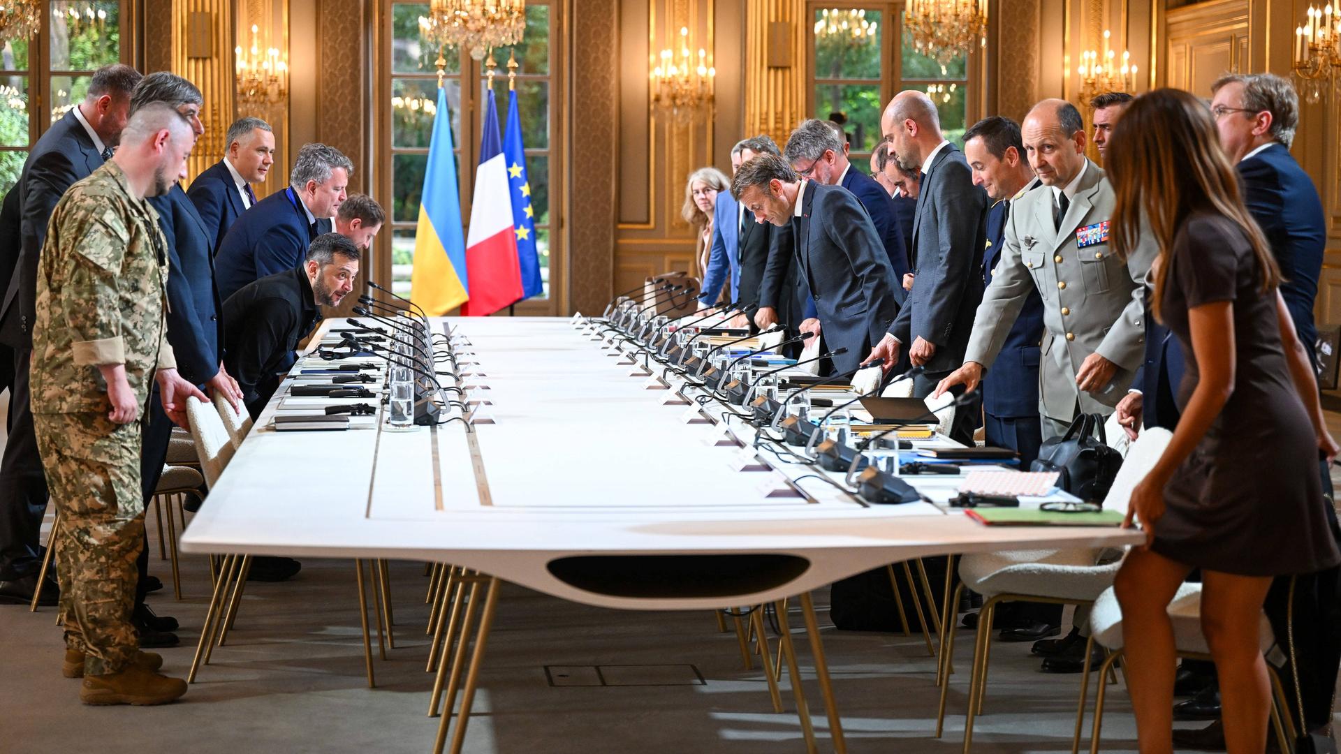 Der französische Präsident Macron und andere Politiker und Militärs begrüßen Wolodymyr Selenskyj im Elysee-Palast am 3. September 2025 an einem großen Tisch mit vielen Mikrofonen Der französische Präsident Macron und andere Politiker und Militärs begrüßen Wolodymyr Selenskyj im Elysee-Palast am 3. September 2025 an einem großen Tisch mit vielen Mikrofonen