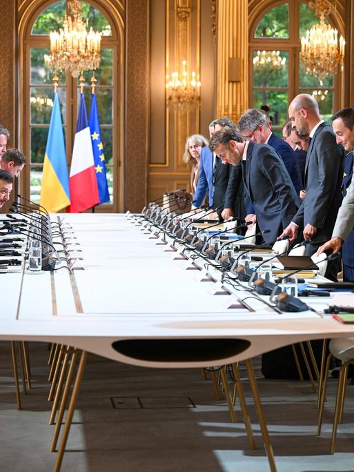 Der französische Präsident Macron und andere Politiker und Militärs begrüßen Wolodymyr Selenskyj im Elysee-Palast am 3. September 2025 an einem großen Tisch mit vielen Mikrofonen