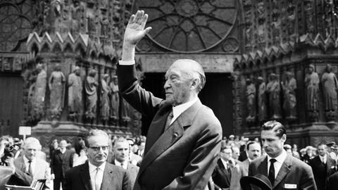 Bundeskanzler Konrad Adenauer winkt am 08.07.1962 vor der Kathedrale in Reims der französischen Bevölkerung zu. 