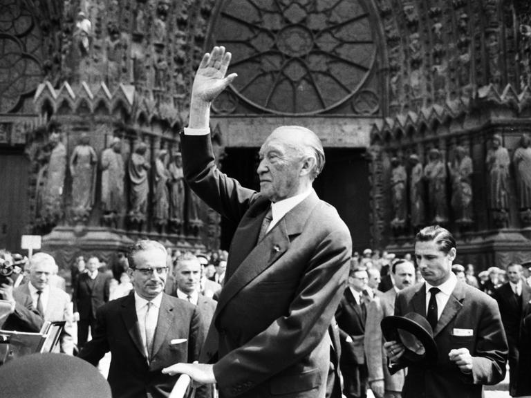 Bundeskanzler Konrad Adenauer winkt am 08.07.1962 vor der Kathedrale in Reims der französischen Bevölkerung zu. 