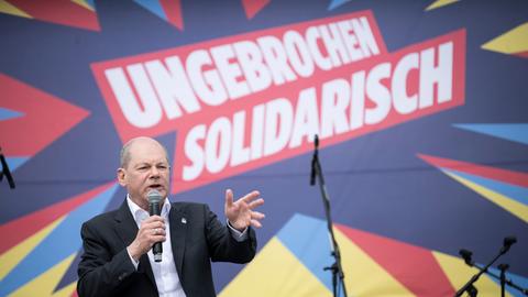 Bundeskanzler Olaf Scholz spricht auf einer 1.-Mai-Kundgebung des Deutschen Gewerkschaftsbunds in ein Mikrofon.