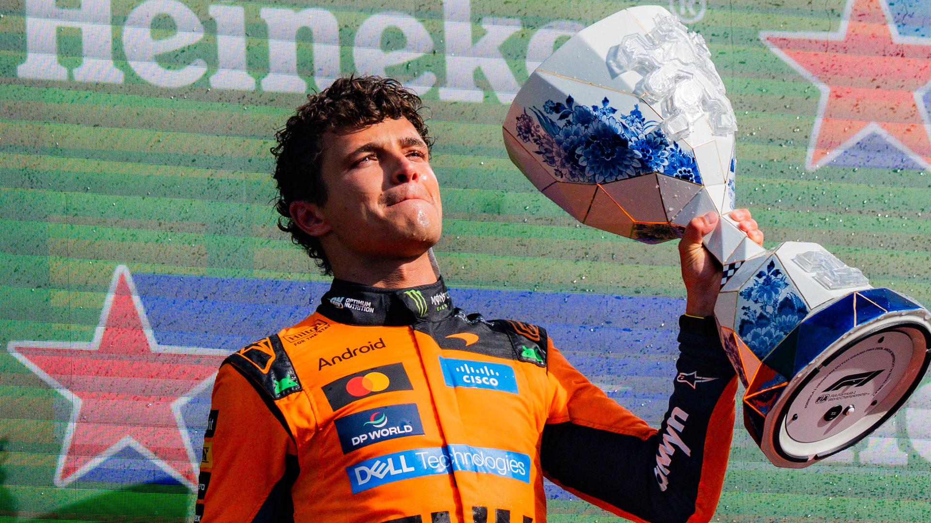 Lando Norris nach seinem Sieg in Zandvoort; er hält den Pokal hoch.