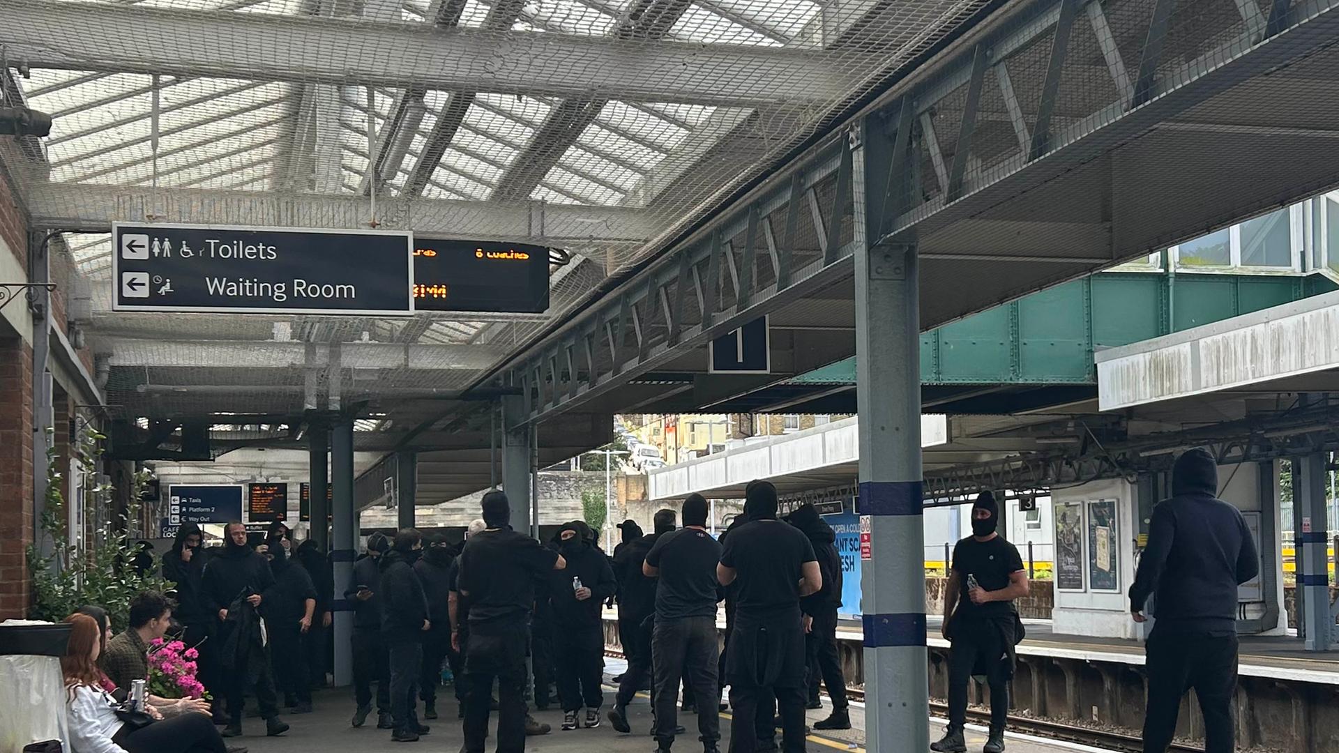 Vermummte Demonstranten am Bahnhof Dover Priory. 