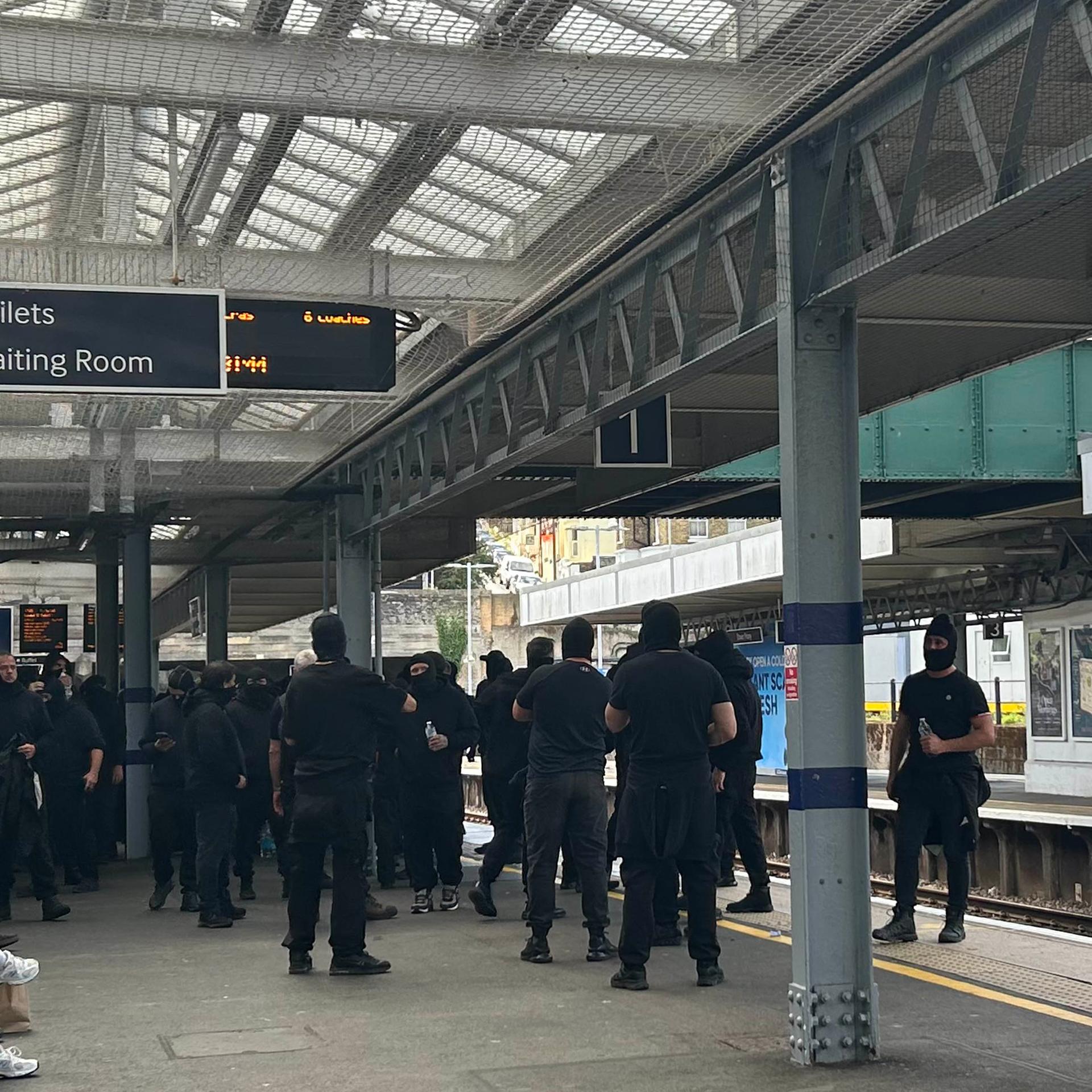 Vermummte Demonstranten am Bahnhof Dover Priory. 