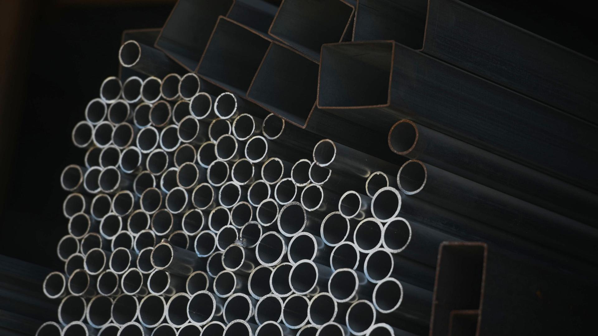 Runde und eckige Rohre liegen übereinander. Runde und eckige Rohre liegen übereinander.