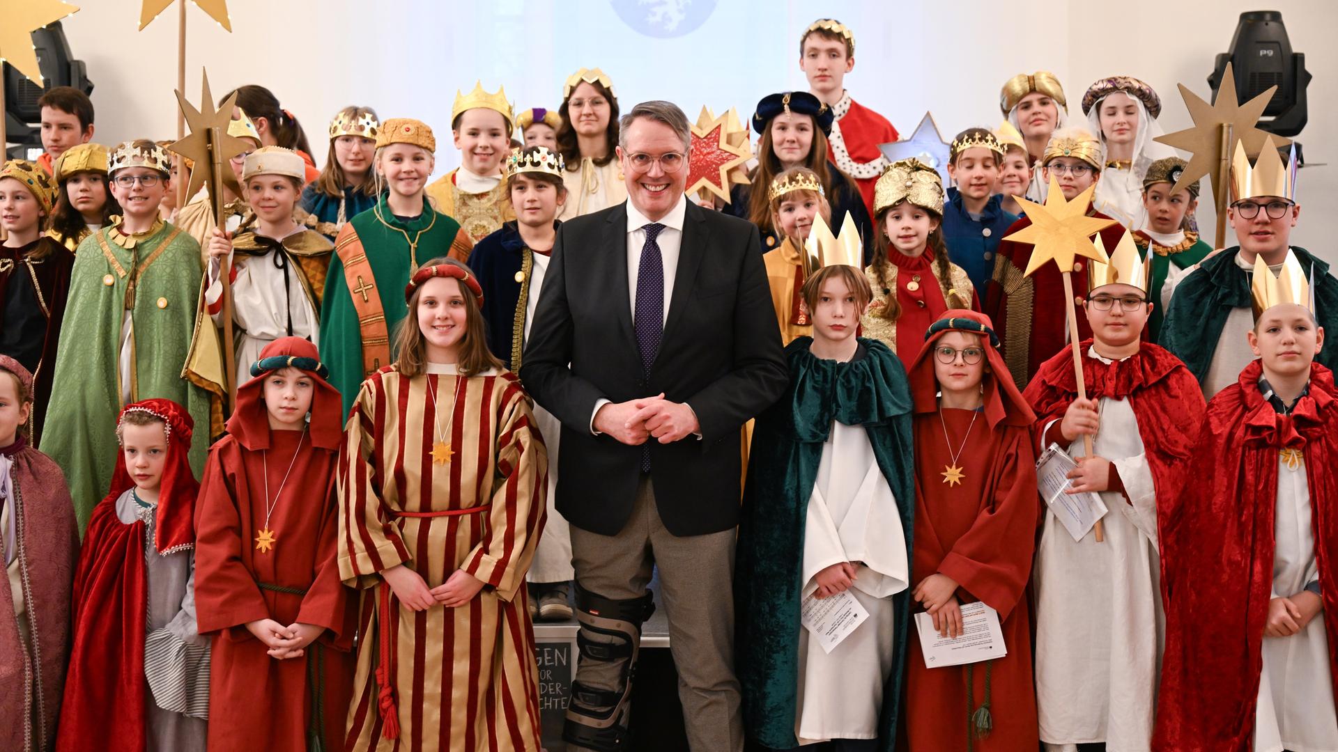 Alexander Schweitzer (M, SPD), Ministerpräsident von Rheinland-Pfalz, steht beim Empfang der Sternsinger im Festsaal der Staatskanzlei zwischen den Sternsingern des Bistums Mainz. Alexander Schweitzer (M, SPD), Ministerpräsident von Rheinland-Pfalz, steht beim Empfang der Sternsinger im Festsaal der Staatskanzlei zwischen den Sternsingern des Bistums Mainz.