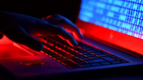 Eine Hand tippt auf der Tastatur eines Laptops 
