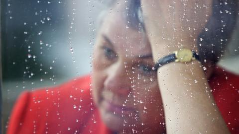 Nachdenkliche Frau an einem Fenster.