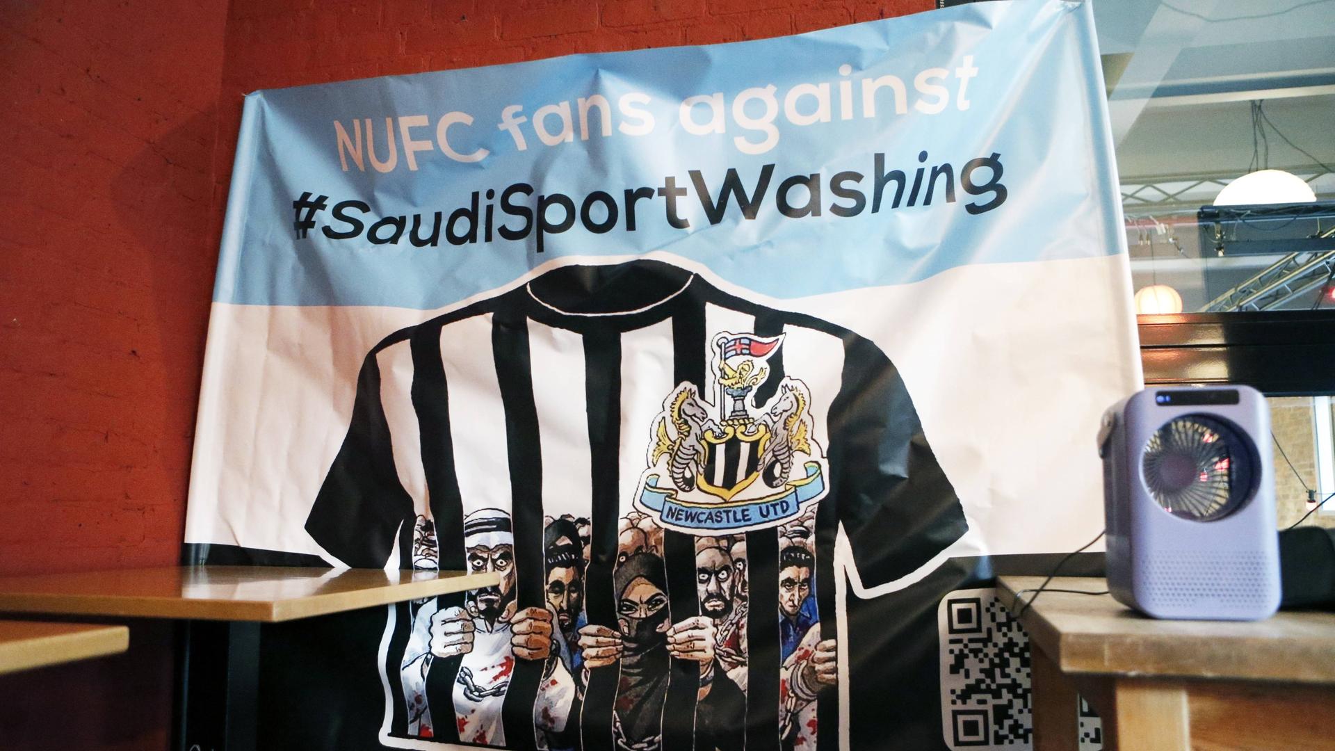 Ein blau-weißes Banner mit der Aufschrift "NUFC fans against #SaudiSportsWashing". 