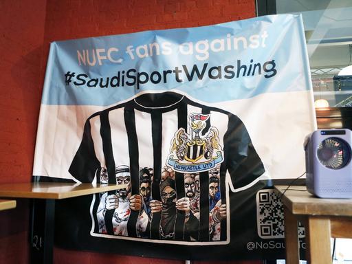 Ein blau-weißes Banner mit der Aufschrift "NUFC fans against #SaudiSportsWashing". 