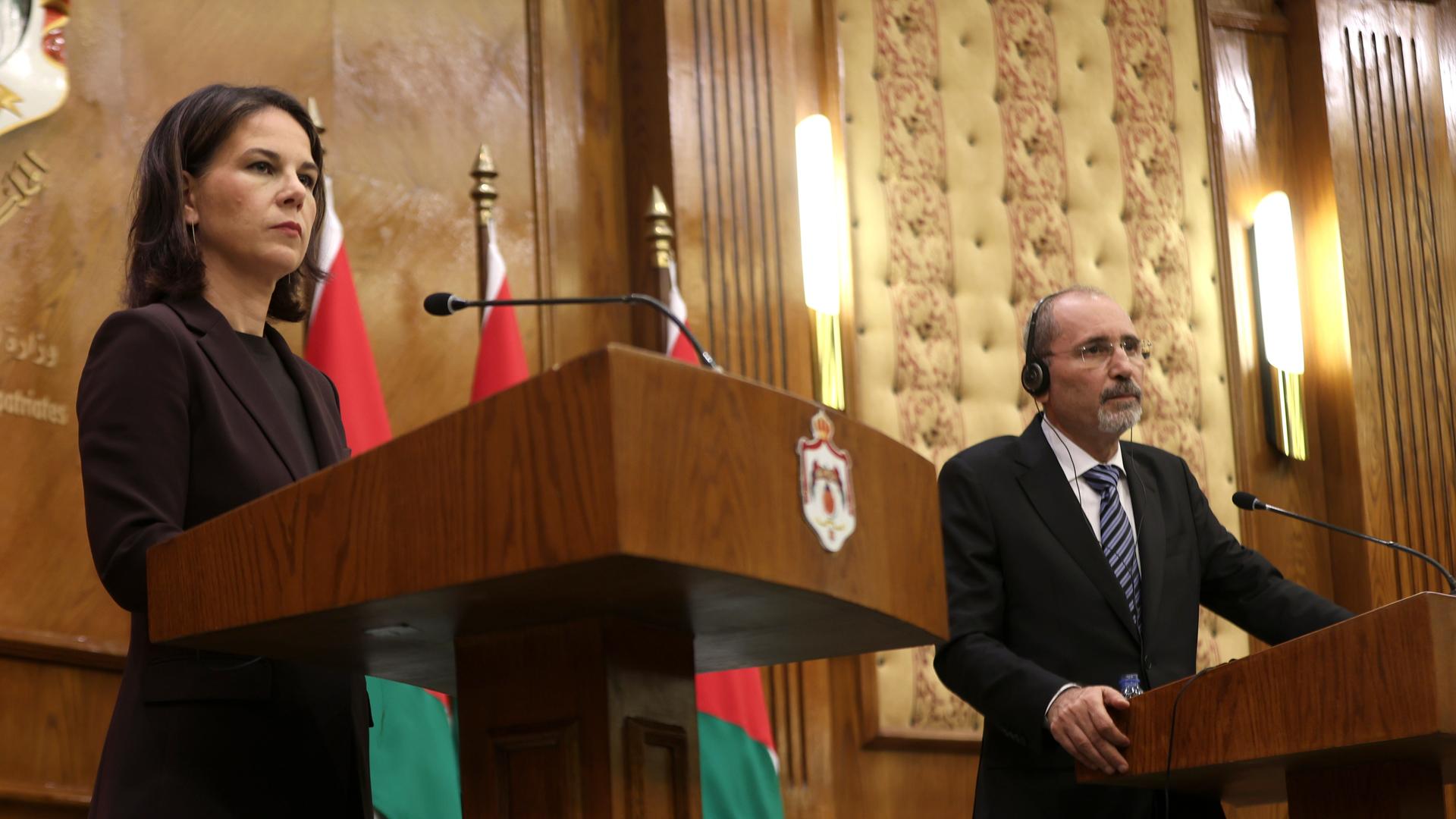 Baerbock steht bei einer Pressekonferenz in Amman am Rednerpult. Neben ihr der jordanische Außenminister Al-Safadi. Beide blicken ernst.