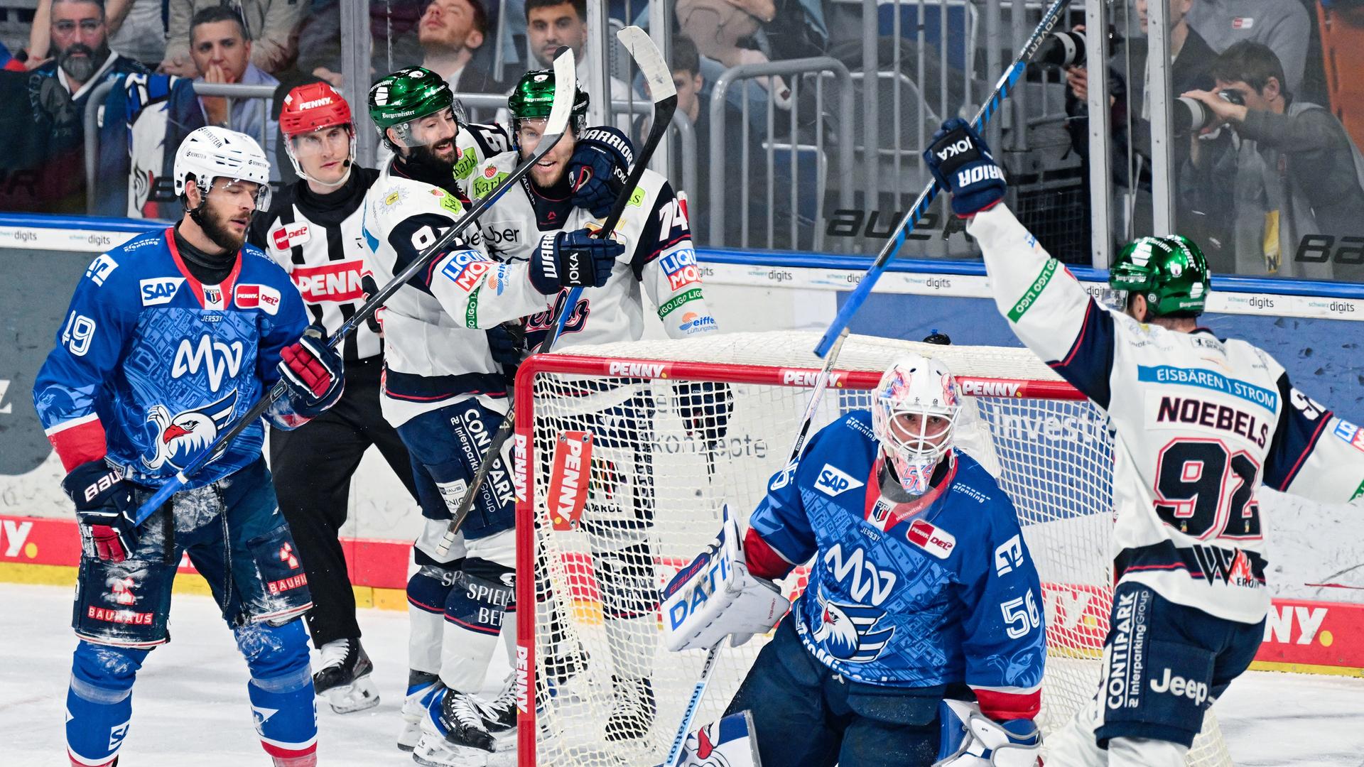 Torschütze Lester Lancaster (4.v.l., Eisbären Berlin) jubelt mit Liam Kirk (3.v.l., Eisbären Berlin) und Marcel Noebels (r, Eisbären Berlin) über das Tor zum 0:3. Im Tor kniet Torhüter Maximilian Franzreb (Adler Mannheim).