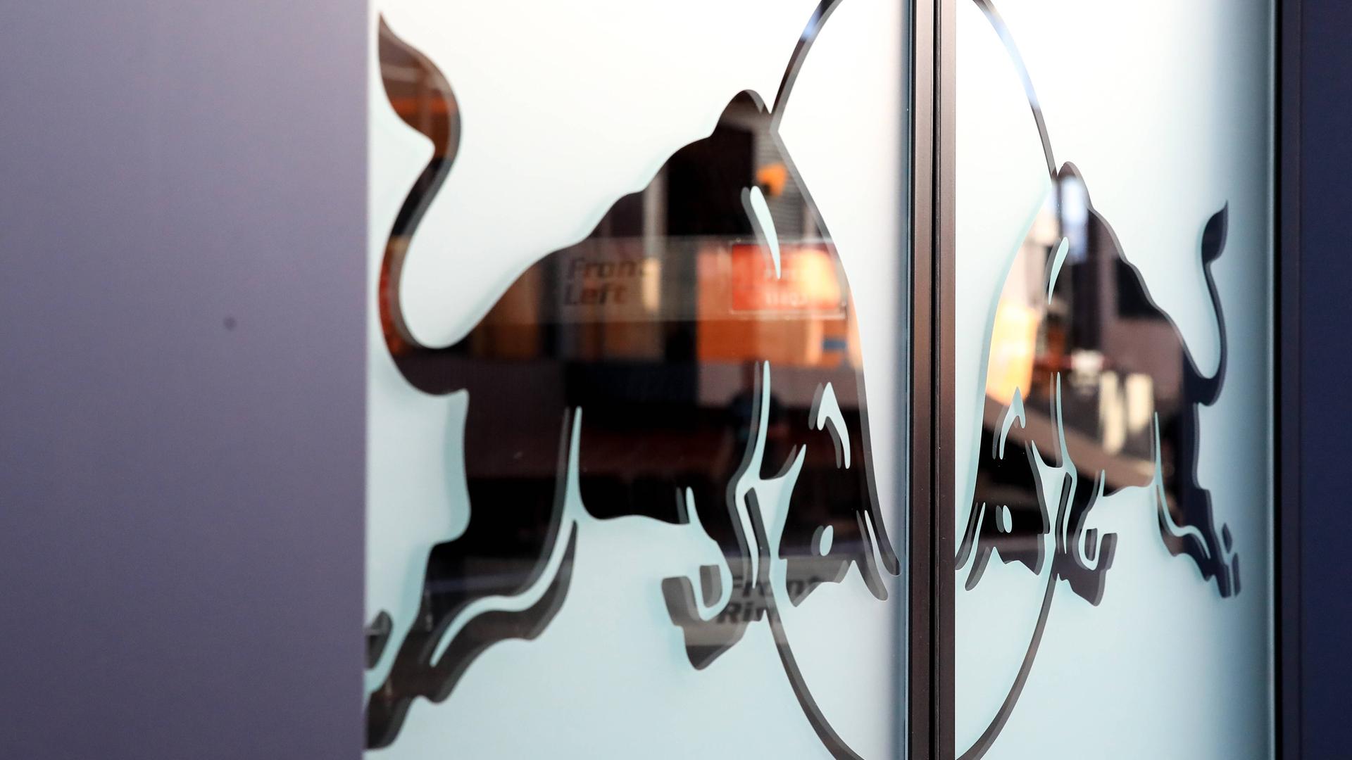 Das Red Bull Logo steht auf einer Glastür. Es zeigt zwei kämpfende Stiere. Das Red Bull Logo steht auf einer Glastür. Es zeigt zwei kämpfende Stiere.