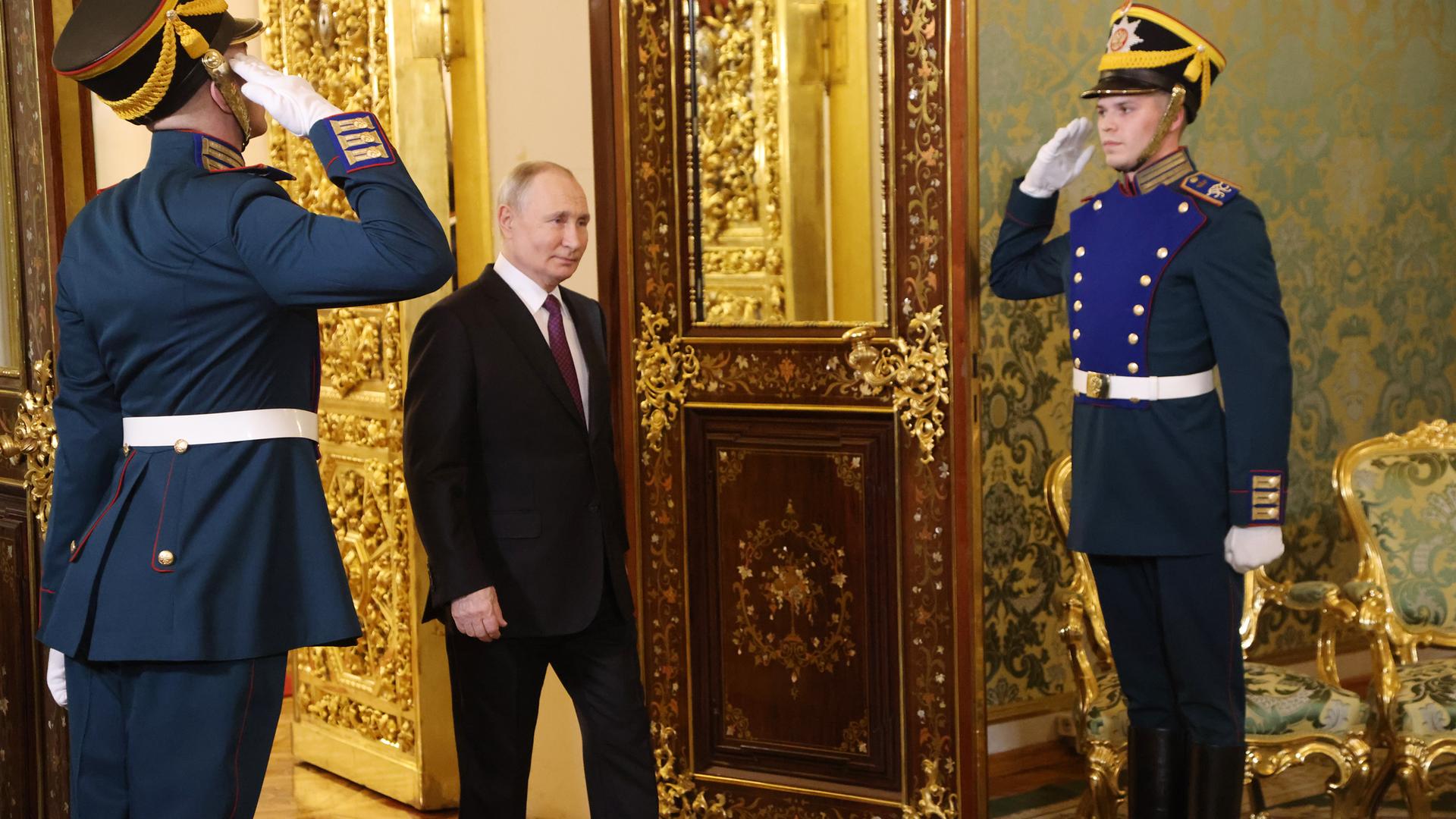 Der russische Präsident Wladimir Putin betritt einen Saal im Kremlpalast in Moskau, zwei Soldaten salutieren.