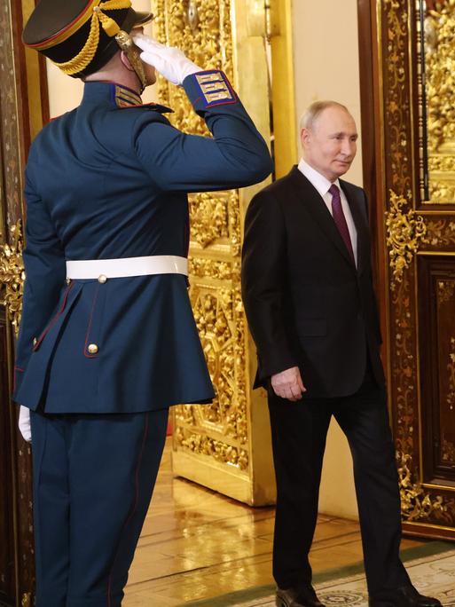 Der russische Präsident Wladimir Putin betritt einen Saal im Kremlpalast in Moskau, zwei Soldaten salutieren.