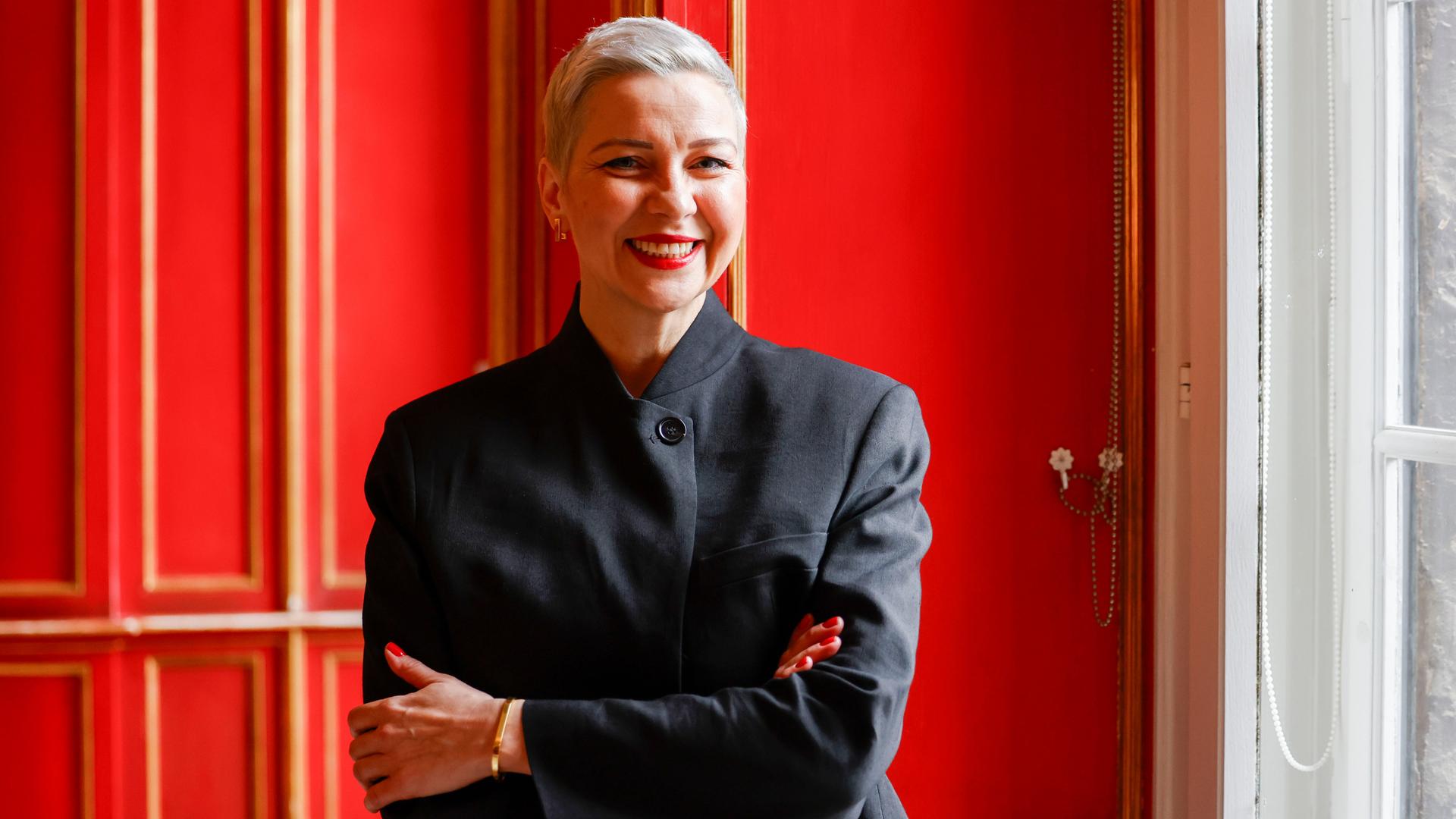 Maria Kolesnikowa steht im Rathaus von Aachen vor einer roten Tür. Sie lächelt.