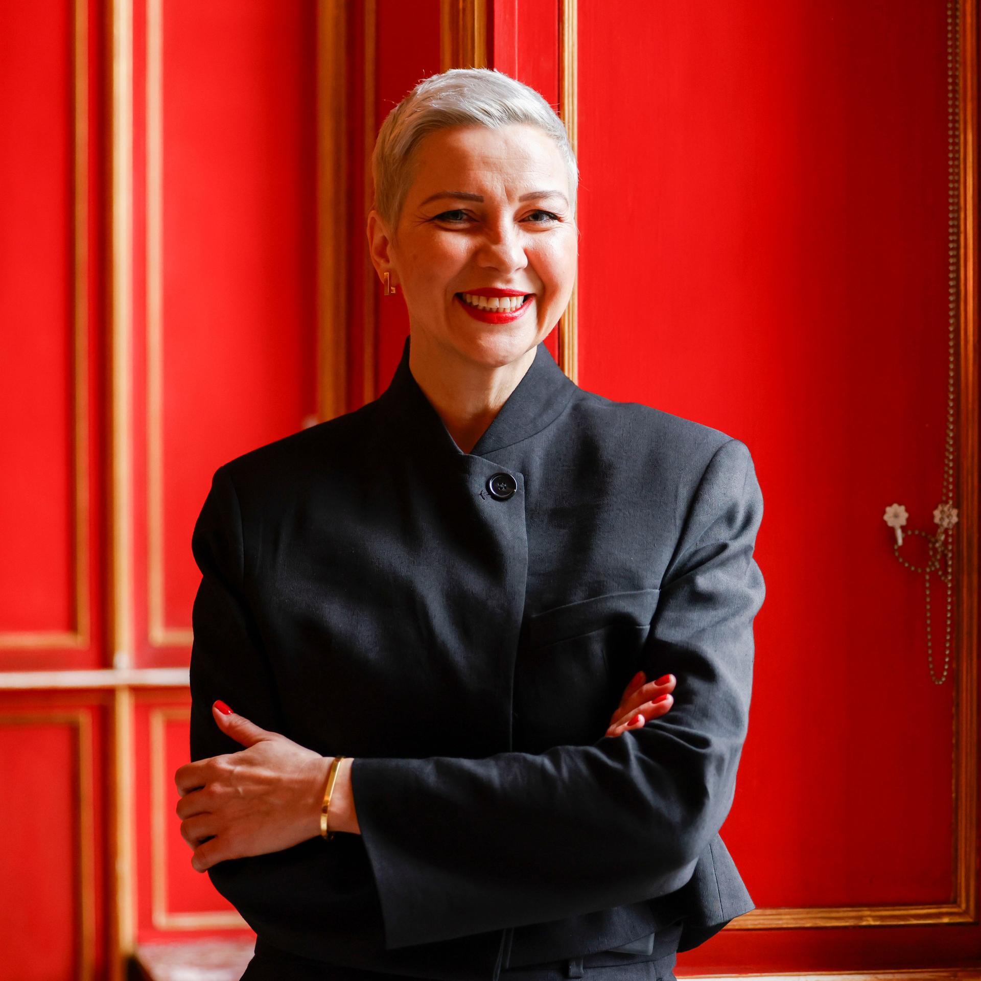 Die Bürgerrechtlerin Maria Kolesnikowa steht im Aachener Rathaus vor einer roten Tür und lächelt.