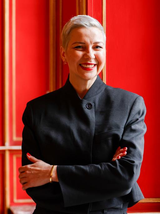 Die Bürgerrechtlerin Maria Kolesnikowa steht im Aachener Rathaus vor einer roten Tür und lächelt.