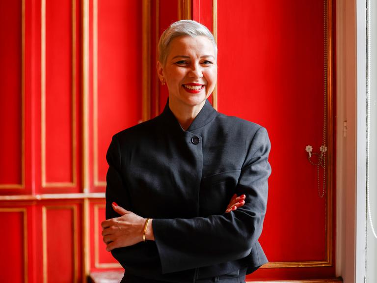 Die Bürgerrechtlerin Maria Kolesnikowa steht im Aachener Rathaus vor einer roten Tür und lächelt.