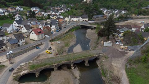 Luftaufnahme des Orts Kreuzberg im Ahrtal: Gras wächst auf der ehemaligen historischen Eisenbahnbrücke über der Ahr.