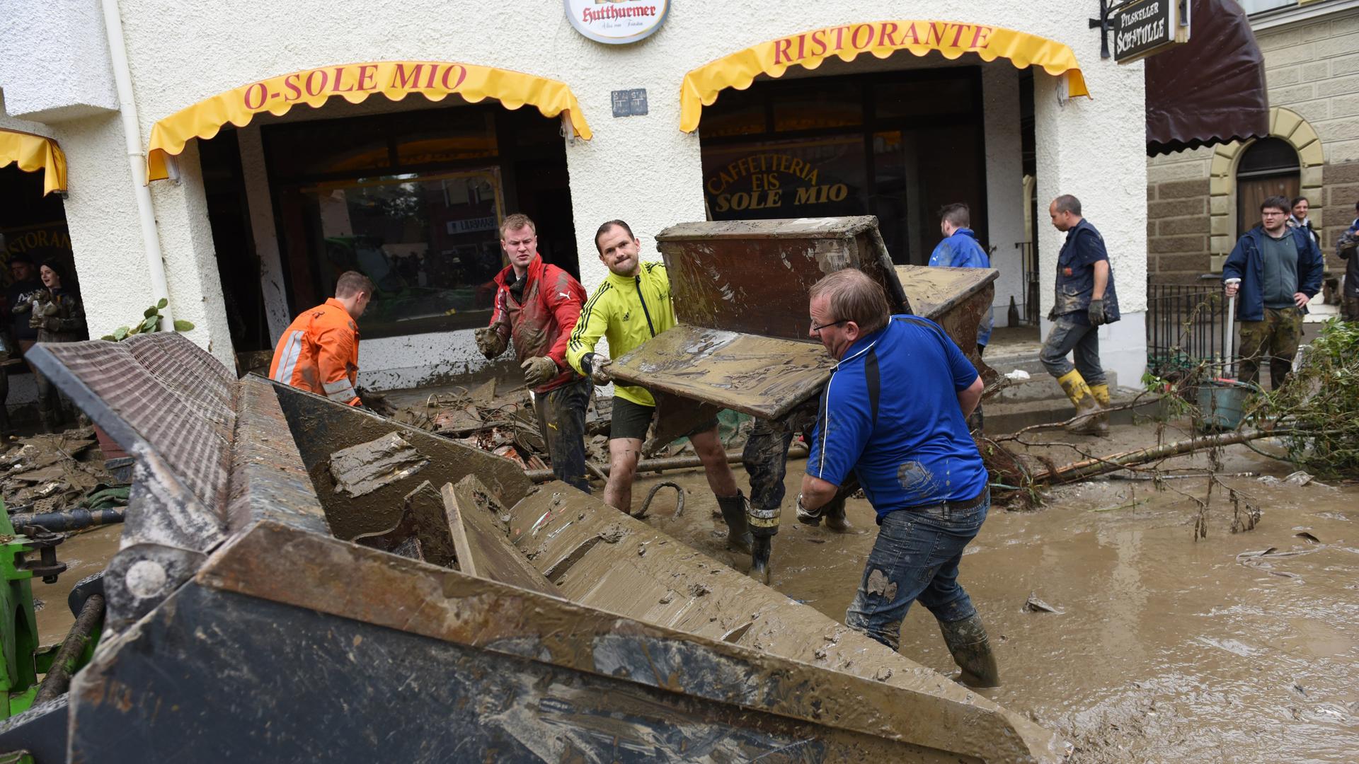 Im bayerischen Simbach am Inn werfen eine vom Hochwasser verschlammte Bank auf die Schaufel eines Radladers. 