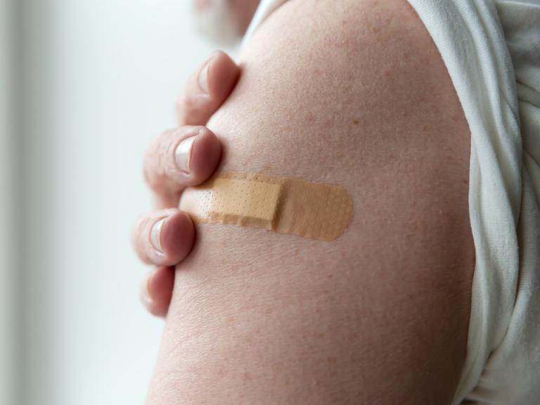 Ein Pflaster auf dem Oberarm nach einer Impfung.