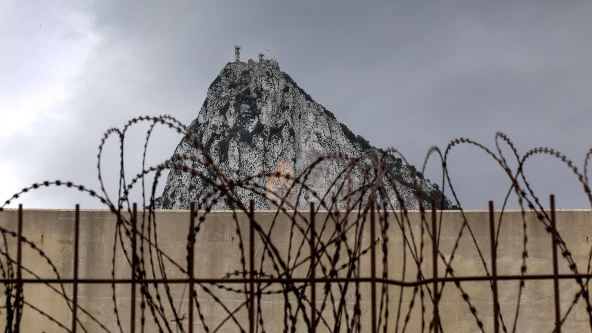Zaun mit Stacheldraht auf spanischem Gebiet, mit dem Blick auf den Gibraltar Felsen Zaun mit Stacheldraht auf spanischem Gebiet, mit dem Blick auf den Gibraltar Felsen