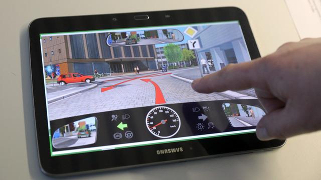 Ein Tablet zeigt eine Verkehrssituation bei einer theoretischen Führerschein-Prüfung.
