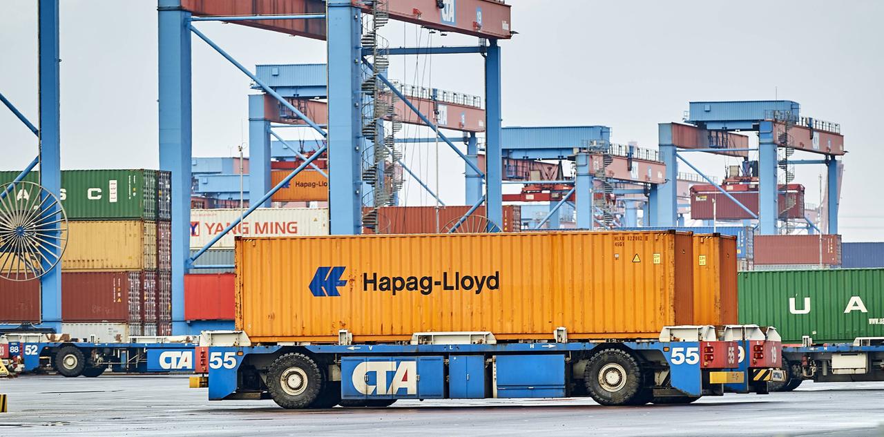 Ein Automated Guided Vehicles (AGV) mit einem Container der Reederei Hapag Lloyd. Die autonom fahrenden Transportfahrzeuge werden im CTA mit Öko-Strom betrieben und für den fahrerlosen Transport zwischen den Container-Brücken und dem Containerlager eingesetzt. 