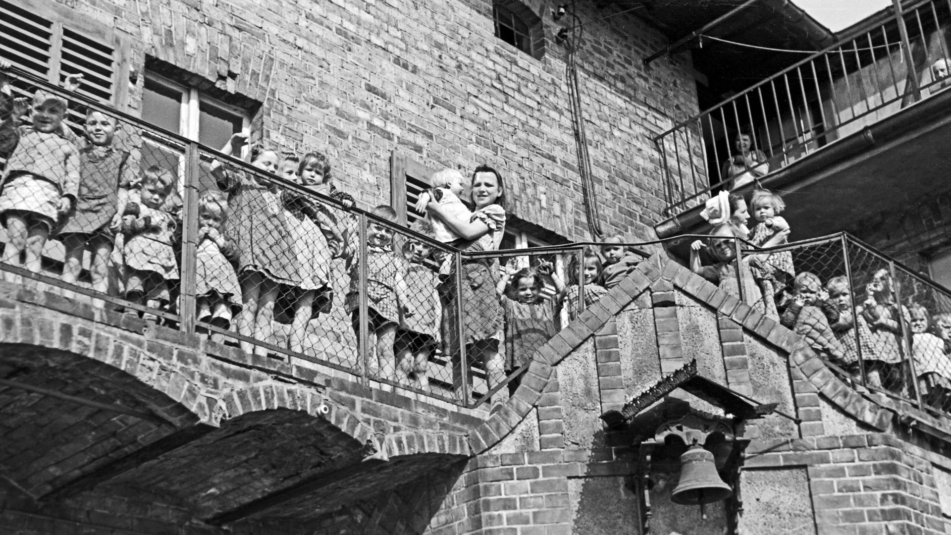 Schwestern und Kinder stehen auf diesem Schwarzweiß-Foto im Außenbereich eines Kinderheims in Frankfurt Oder.