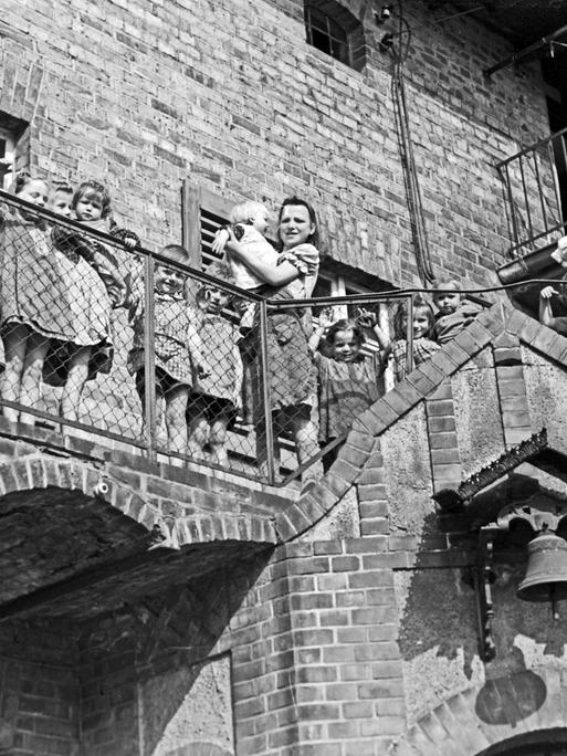Schwestern und Kinder stehen auf diesem Schwarzweiß-Foto im Außenbereich eines Kinderheims in Frankfurt Oder.