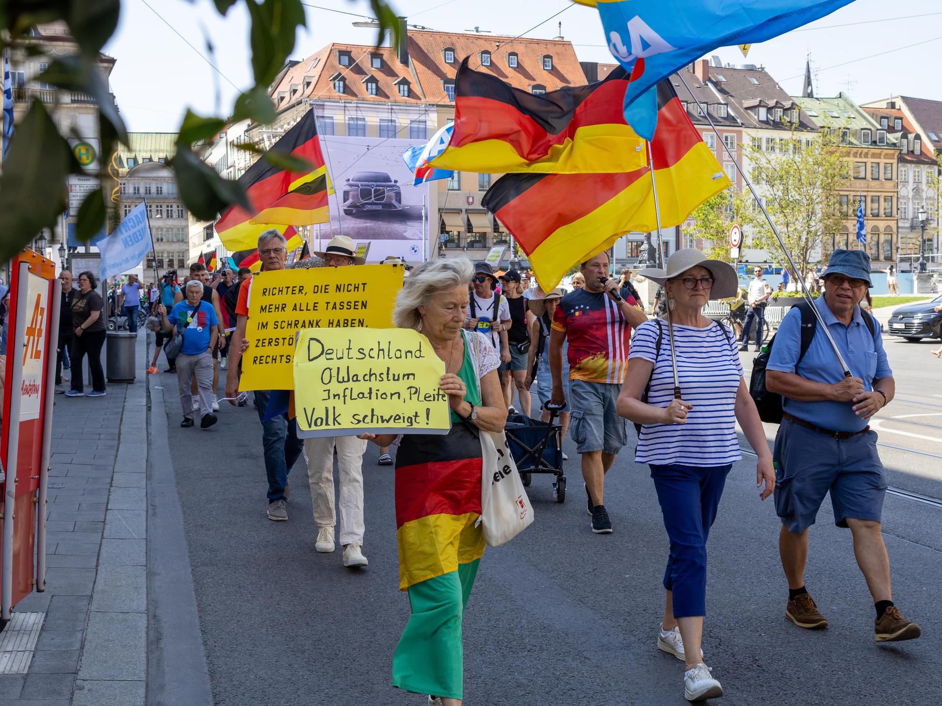 Bei einer Demonstration gegen die Politik der Bundesregierung in der Münchner Innenstadt tragen Teilnehmer Plakate, Deutschlandfahnen und Fahnen der Partei AfD. Bei einer Demonstration gegen die Politik der Bundesregierung in der Münchner Innenstadt tragen Teilnehmer Plakate, Deutschlandfahnen und Fahnen der Partei AfD.
